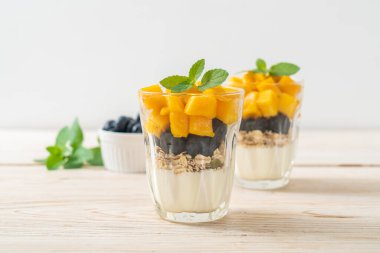 Ev yapımı taze mango ve yoğurt ve granola ile taze yaban mersini. Sağlıklı yemek tarzı.