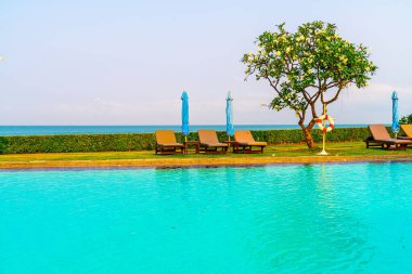 Havuz kenarındaki havuz, havuz, şemsiye, deniz manzaralı havuz tatilleri ve tatil konsepti.