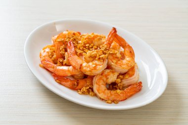 Kızarmış karides ya da beyaz tabakta sarımsaklı karides - deniz ürünleri tarzı.