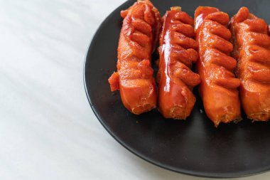 Siyah tabakta kızarmış sosis şişi.