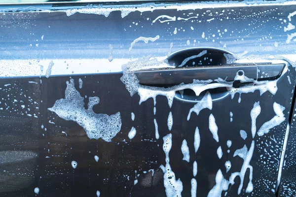 Yıkama köpüğüyle yakın plan gri araba.