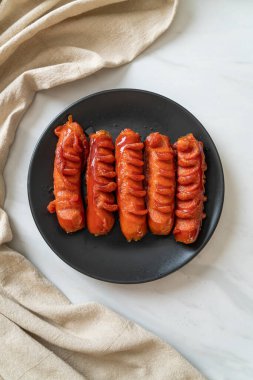 Siyah tabakta kızarmış sosis şişi.