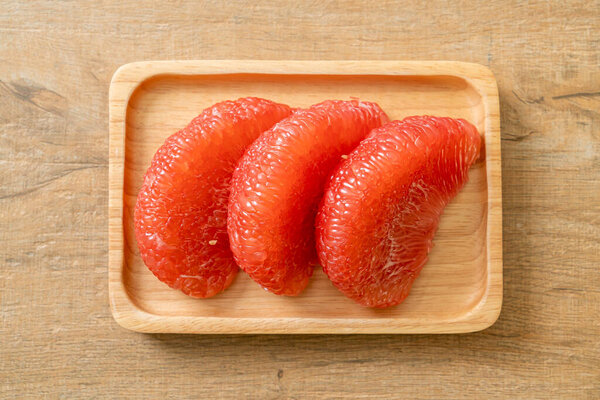 fresh red pomelo fruit or grapefruit on plate