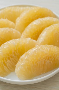 Taze soyulmuş zeytin, greyfurt ya da beyaz tabakta Shaddock.