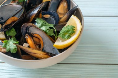 Limonlu bir kasede otlu taze midyeler.