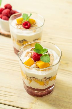 Ev yapımı taze mango ve yoğurt ve granola ile taze ahududu. Sağlıklı yemek tarzı.