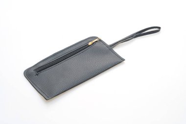 Beyaz arkaplanda siyah deri el çantası var.