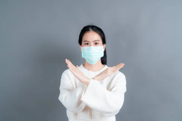 Asian woman wearing medical face mask protects filter dust pm2.5 anti-pollution, anti-smog, and COVID-19 on grey background