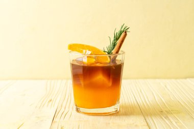 Bir bardak buzlu americano sade kahve ve biberiye ve tarçınla süslenmiş portakal ve limon suyu.