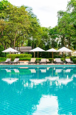 Şemsiye ve sandalye otel tatil ve tatil merkezinde yüzme havuzunda.
