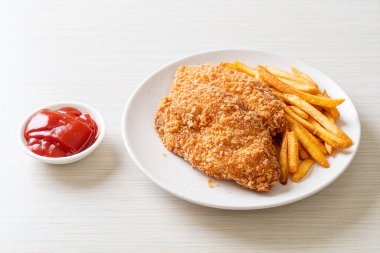 Kızarmış tavuk göğsü fileto biftek yanında patates kızartması ve ketçap.