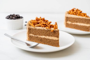 Ev yapımı kahve badem keki beyaz tabakta.