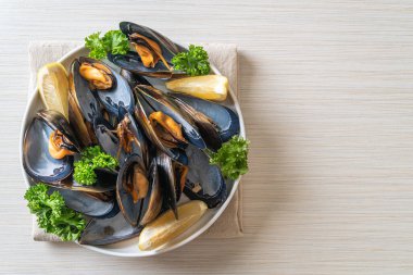 Limonlu bir kasede otlu taze midyeler.