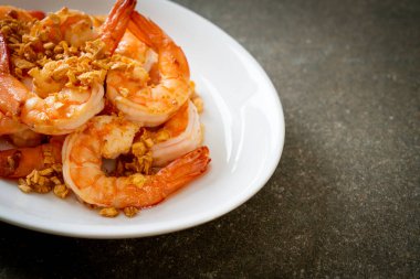 Kızarmış karides ya da beyaz tabakta sarımsaklı karides - deniz ürünleri tarzı.