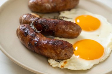 Kahvaltıda omlet ve kızarmış domuz sosisi.