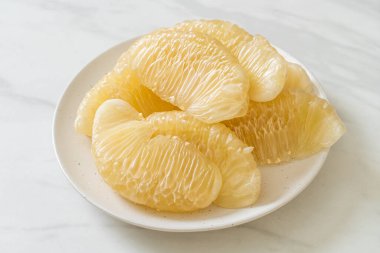 Taze soyulmuş zeytin, greyfurt ya da beyaz tabakta Shaddock.