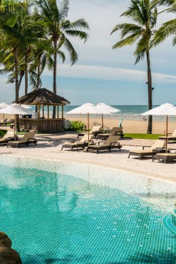 Plaj geçmişine sahip otel havuzunda yüzme havuzu etrafında plaj sandalyesi - tatil ve tatil kavramı