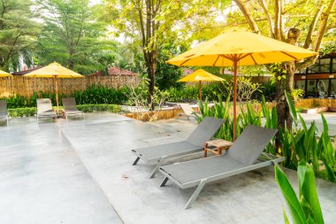 Otelin havuzunda havuz çevresinde şemsiye ve bilardo takımı.