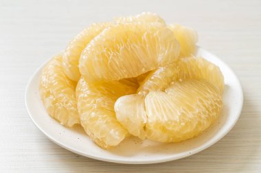 Taze soyulmuş zeytin, greyfurt ya da beyaz tabakta Shaddock.