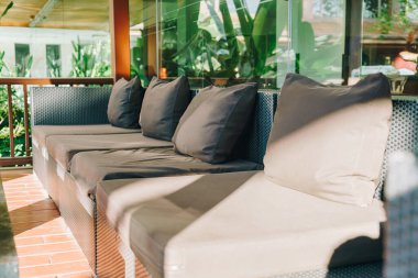 Balkon bölgesindeki kanepede rahat bir yastık dekorasyonu.