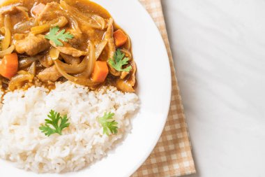 Dilimlenmiş domuz eti, havuç ve soğanlı Japon körili pilavı. Asya usulü.