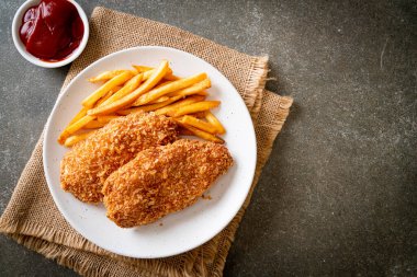 Kızarmış tavuk göğsü fileto biftek yanında patates kızartması ve ketçap.