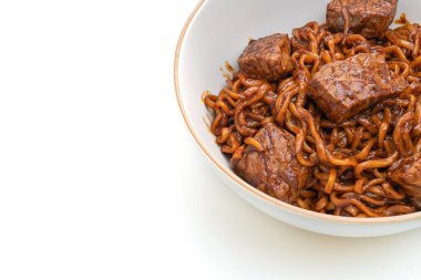 Jjapaguri ya da Chapaguri, Koreli siyah fasulye baharatlı erişteler beyaz arka planda izole edilmiş.