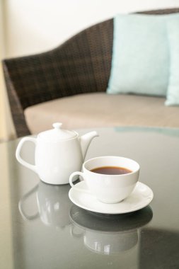 Masada çaydanlık olan beyaz çay fincanı