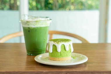Kafe restoranındaki yeşil çay fincanlı kibrit yeşil çay peynirli kek.