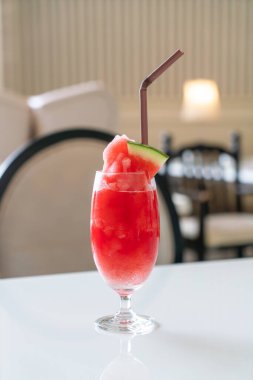 Kafe restoranındaki masada taze karpuz suyu bardağı var.