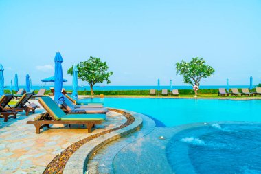 Havuz kenarındaki havuz, havuz, şemsiye, deniz manzaralı havuz tatilleri ve tatil konsepti.