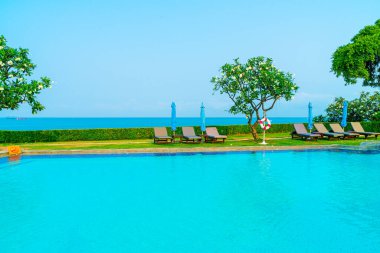 Havuz kenarındaki havuz, havuz, şemsiye, deniz manzaralı havuz tatilleri ve tatil konsepti.