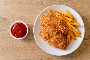 Kızarmış tavuk göğsü fileto biftek yanında patates kızartması ve ketçap.