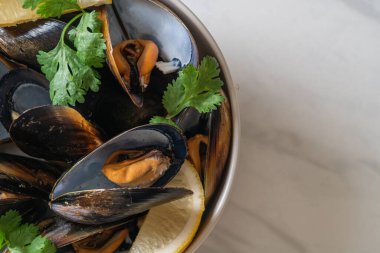 Limonlu bir kasede otlu taze midyeler.