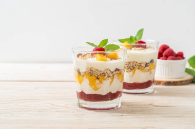 Ev yapımı taze mango ve yoğurt ve granola ile taze ahududu. Sağlıklı yemek tarzı.