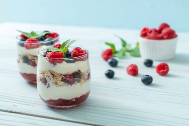 Ev yapımı ahududu ve yaban mersinli yoğurt ve granola. Sağlıklı yemek tarzı.