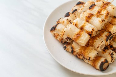 Izgara tüp şeklinde balık ezmeli kek ya da tabakta mürekkep balığı şişi.