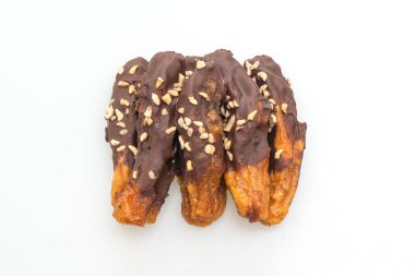 Güneş ışığı, muzlu çikolatayı kurutur ya da muz soslu çikolatayı beyaz arka planda izole eder.