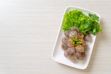 Şeffaf toplara Saku Sai Moo ya da buharda pişirilmiş Tapioca köfteleri deniyor.