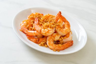 Kızarmış karides ya da beyaz tabakta sarımsaklı karides - deniz ürünleri tarzı.