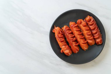 Siyah tabakta kızarmış sosis şişi.