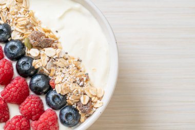 Ev yapımı yoğurt kasesi, ahududu, yaban mersini ve granola. Sağlıklı yemek tarzı.