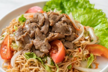 Beyaz tabakta domuz etli hazır şehriye salatası. Asya usulü.