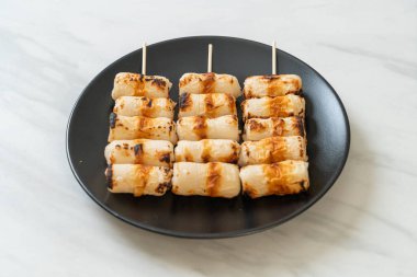 Izgara tüp şeklinde balık ezmeli kek ya da tabakta mürekkep balığı şişi.