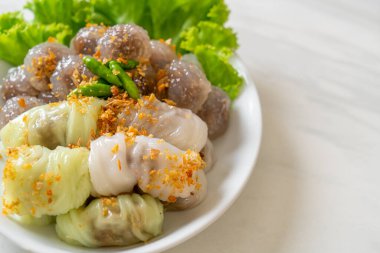 Şeffaf toplara Saku Sai Moo ya da Buharlı Tapioca Köfte Topları ve (Kow Griep Pag Mor) Domuz Buharlı Pirinç Paketleri ya da Haşlanmış Pirinç Kabuklu Mantı denir.