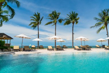 Plaj geçmişine sahip otel havuzunda yüzme havuzu etrafında plaj sandalyesi - tatil ve tatil kavramı