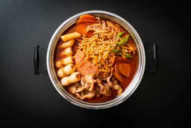Budae Jjigae ya da Budaejjigae (ordu yahnisi ya da ordu üssü). Kimchi, konserve jambon, sosis, ramen eriştesi ve çok daha popüler Kore usulü sıcak yemek ile dolu.
