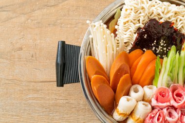 Budae Jjigae ya da Budaejjigae (ordu yahnisi ya da ordu üssü). Kimchi, konserve jambon, sosis, ramen eriştesi ve çok daha popüler Kore usulü sıcak yemek ile dolu.