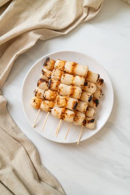 Izgara tüp şeklinde balık ezmeli kek ya da tabakta mürekkep balığı şişi.