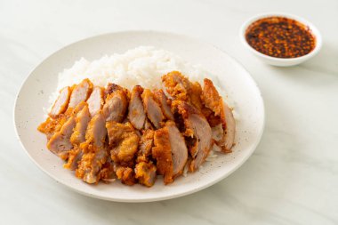 Baharatlı soslu pilav üzerine kızarmış domuz eti.